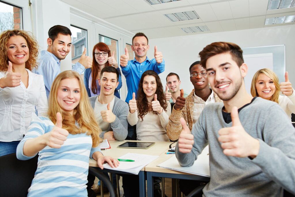 Auszubildende in Klassenraum halten Daumen hoch